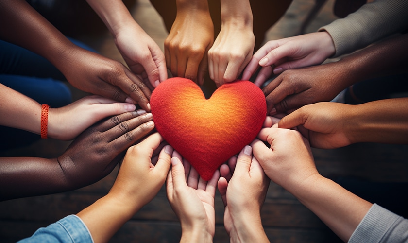 close-up of hands of diverse individuals joining together to form a heart post 3